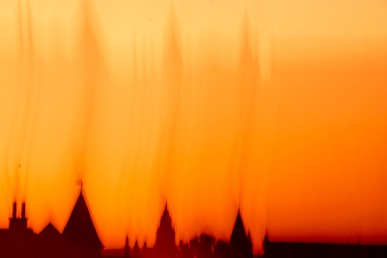 Mainzer Dom St. Martin, Kinoparkhaus Silhouette vom Dom und Gebäuden in der Altstadt vor einem orangefarbenen Sonnenuntergang.